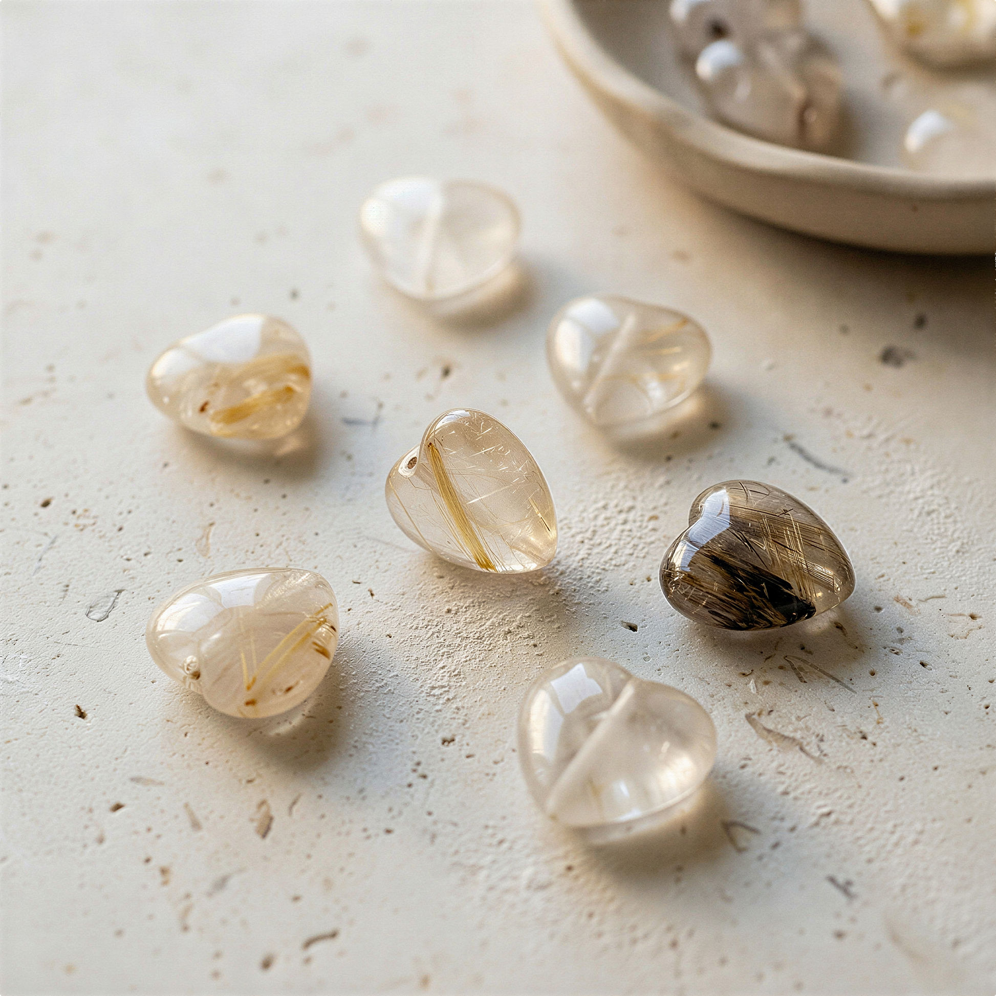 Gold rutilated quartz heart bead resting on soft linen with gentle natural light and organic textures