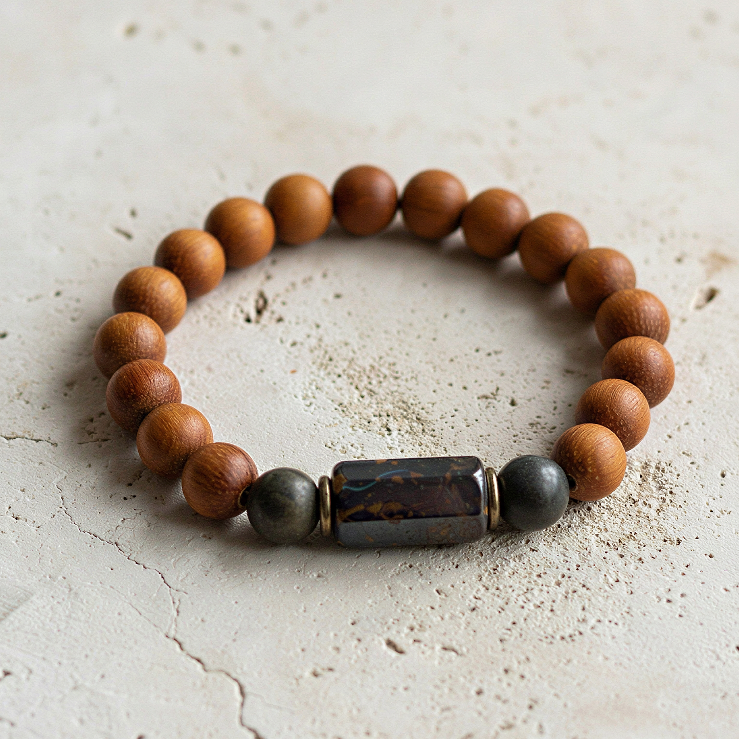 Bayong wood and boulder opal bracelet resting on natural stone with soft, diffused forest light