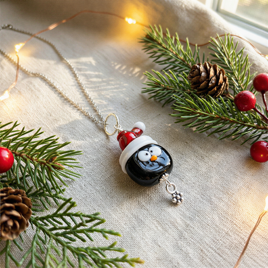 Holiday penguin glass bead necklace displayed with refined lighting, enhanced clarity and color, elegant minimal backdrop