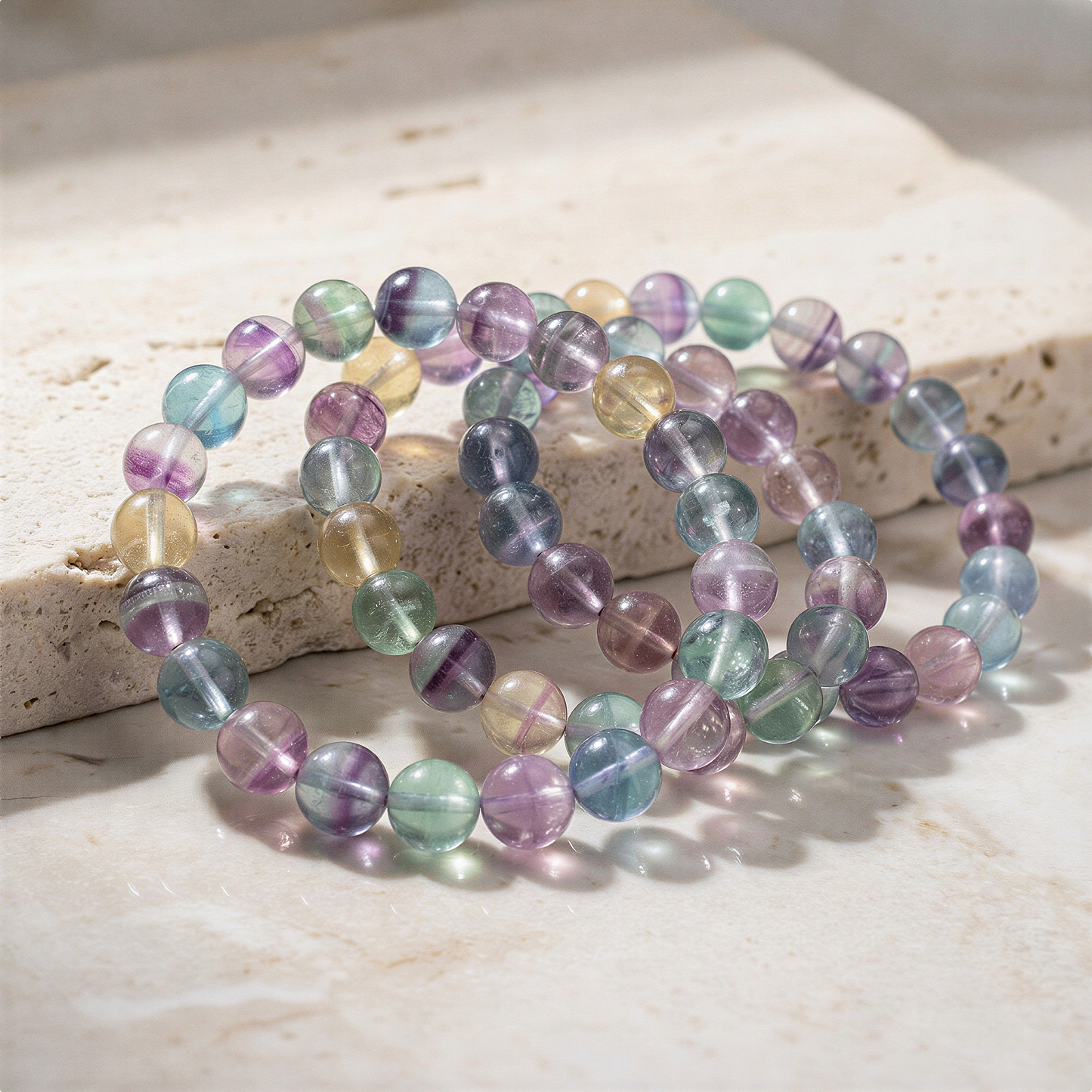 Rainbow fluorite stretchy bracelet with mixed bead sizes on neutral backdrop, refined clarity and gentle color enhancement