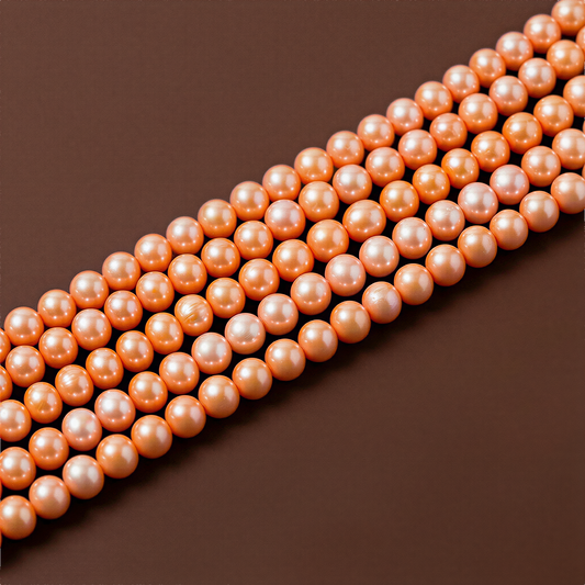 Small orange freshwater pearl strand resting against a warm chocolate-brown backdrop, softly lit to reveal natural luster and organic texture