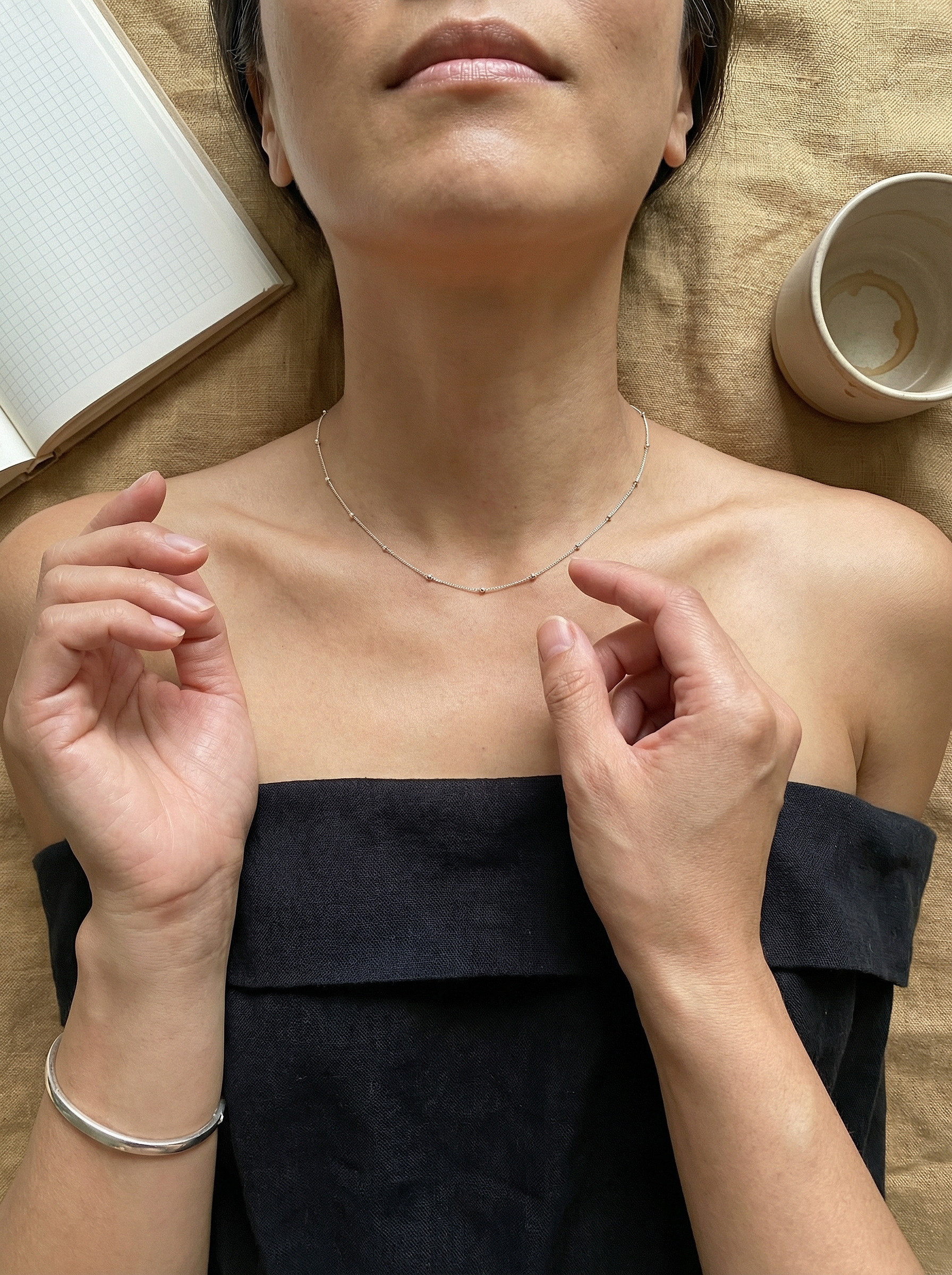 Overhead study of model on flax linen with sterling satellite chain and minimal props