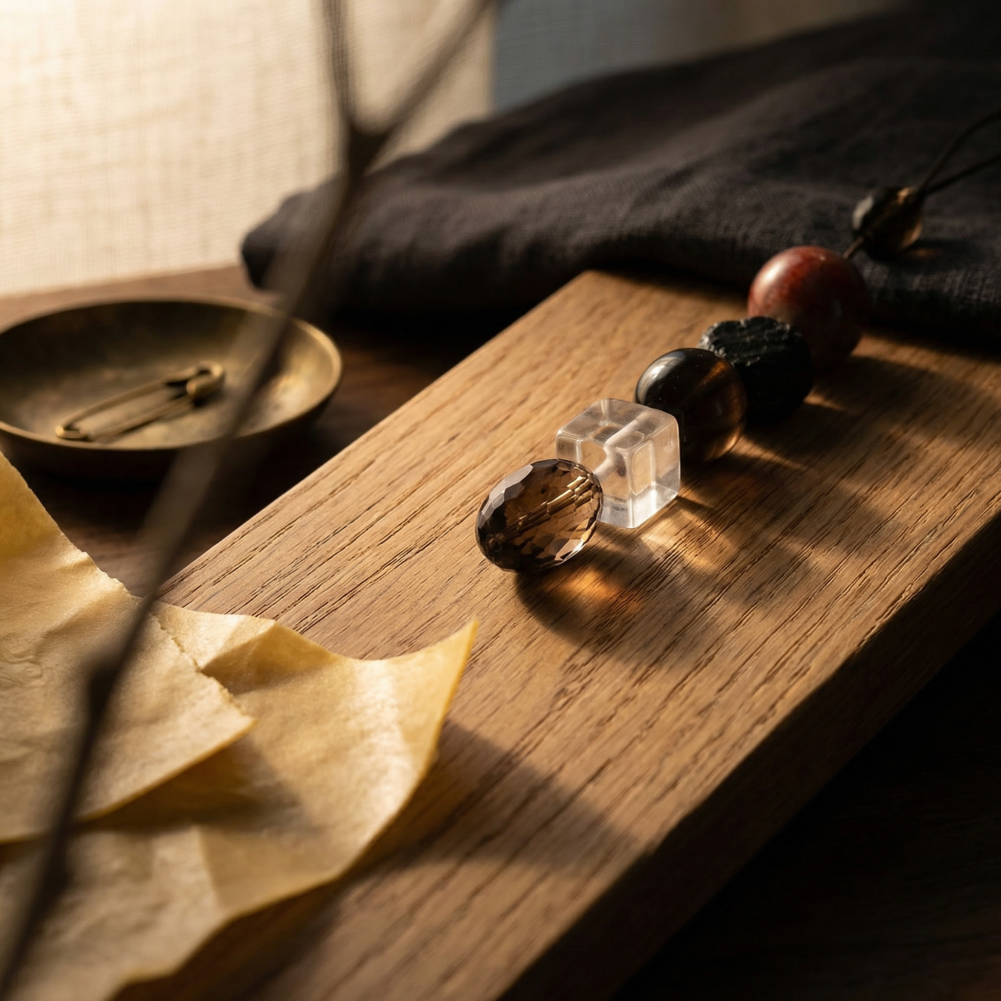 Bead bundle on warm oak with linen backdrop, beeswax paper and soft directional light.
